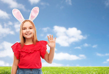 Image showing happy girl wearing easter bunny ears waving hand