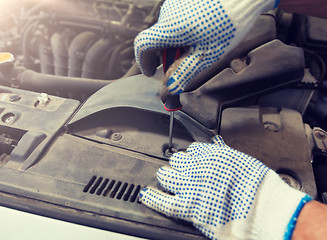 Image showing mechanic man with wrench repairing car at workshop