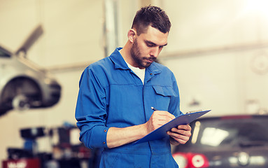 Image showing auto mechanic man with clipboard at car workshop