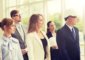 Image showing business team in helmets walking along office