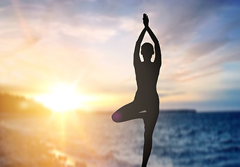 Image showing silhouette of woman making yoga over sea sunset