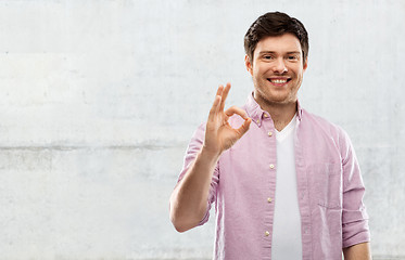 Image showing smiling young man showing ok hand sign