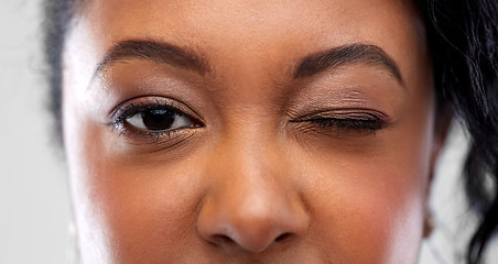 Image showing close up of african american woman winking one eye