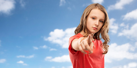 Image showing teenage girl in red t-shirt pointing finger to you