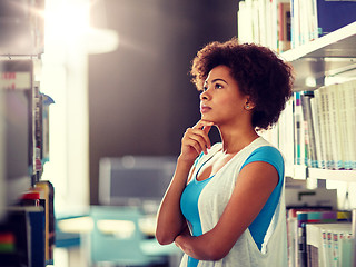 Image showing african student girl choosing book at library