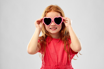 Image showing smiling red haired girl in heart shaped sunglasses