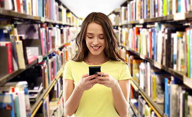 Image showing teenage student girl using smartphone at library