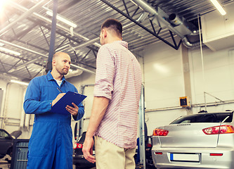 Image showing auto mechanic with clipboard and man at car shop