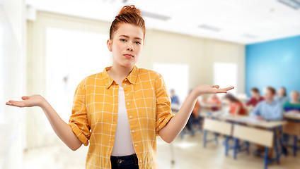 Image showing sad red haired student girl shrugging at school