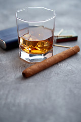 Image showing Glass of whiskey with ice, big cuban cigar, matches and hip flask