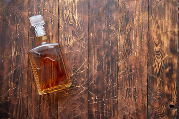 Image showing Bottle of whiskey on wooden table