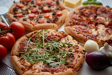 Image showing Three american style pizzas served on a table