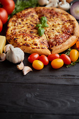 Image showing Delicious italian pizza served on black wooden table