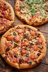 Image showing Composition of three various kinds pizzas on wooden table