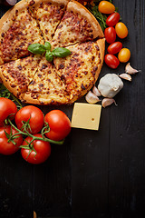 Image showing Delicious italian pizza served on black wooden table