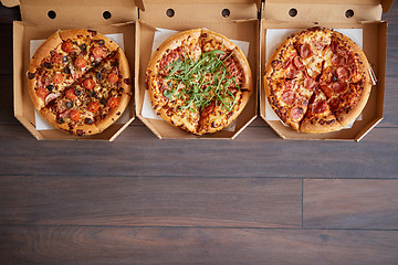 Image showing Three different kind of pizzas in delivery boxes