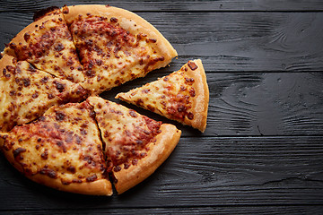Image showing Fluffy pepperoni pizza in american style placed on rusty old black wooden table