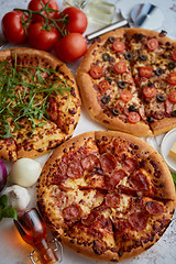 Image showing Three american style pizzas served on a table