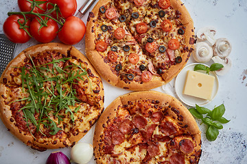 Image showing Three american style pizzas served on a table