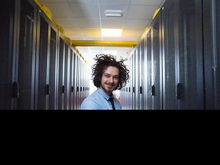 Image showing engineer working on a laptop in server room