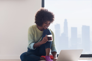 Image showing black woman in the living room on the floor