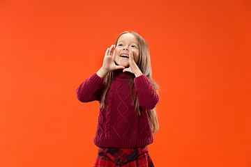 Image showing Isolated on blue young casual teen girl shouting at studio