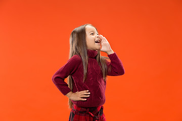 Image showing Isolated on blue young casual teen girl shouting at studio