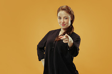 Image showing The happy business woman point you and want you, half length closeup portrait on gold background.