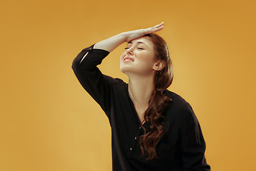 Image showing Beautiful woman looking suprised and bewildered isolated on gold