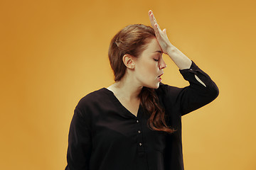 Image showing Beautiful woman looking suprised and bewildered isolated on gold