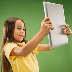 Image showing Teen girl with laptop. Love to computer concept. Attractive female half-length front portrait, trendy green studio backgroud.