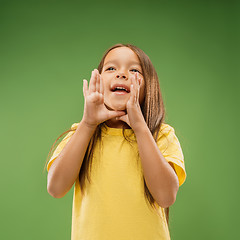 Image showing Isolated on blue young casual teen girl shouting at studio