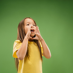 Image showing Isolated on blue young casual teen girl shouting at studio