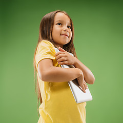 Image showing Teen girl with laptop. Love to computer concept. Attractive female half-length front portrait, trendy green studio backgroud.