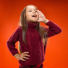 Image showing Isolated on blue young casual teen girl shouting at studio