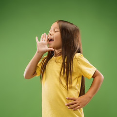 Image showing Isolated on blue young casual teen girl shouting at studio