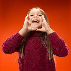 Image showing Isolated on blue young casual teen girl shouting at studio