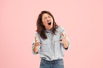 Image showing The young emotional angry woman screaming on studio background