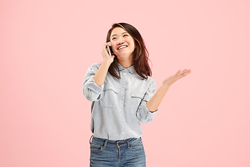 Image showing Young beautiful woman using mobile phone studio on pink color background