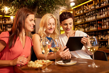 Image showing women with tablet pc at wine bar or restaurant