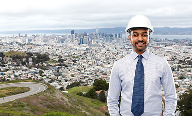 Image showing architect or businessman in helmet over city