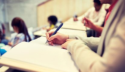 Image showing student writing to notebook at exam or lecture