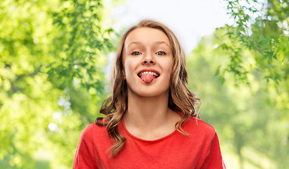 Image showing funny teenage girl in red t-shirt showing tongue