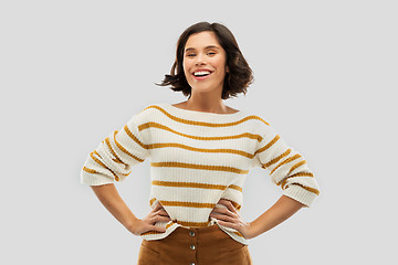 Image showing smiling woman in pullover with hands on hips