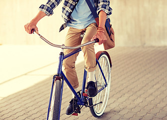 Image showing young hipster man with bag riding fixed gear bike