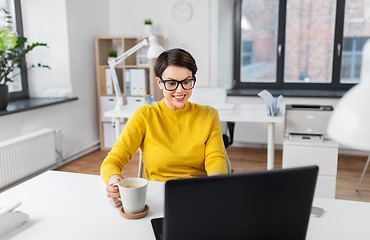 Image showing businesswoman with laptop drinks coffee at office