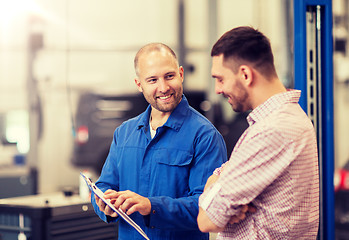 Image showing auto mechanic with clipboard and man at car shop