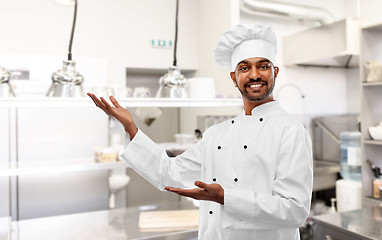 Image showing happy male indian chef presents restaurant kitchen