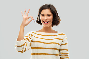 Image showing happy smiling woman in striped pullover showing ok