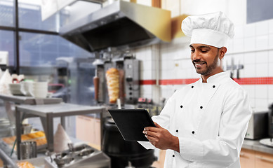 Image showing male indian chef with tablet pc at kebab shop